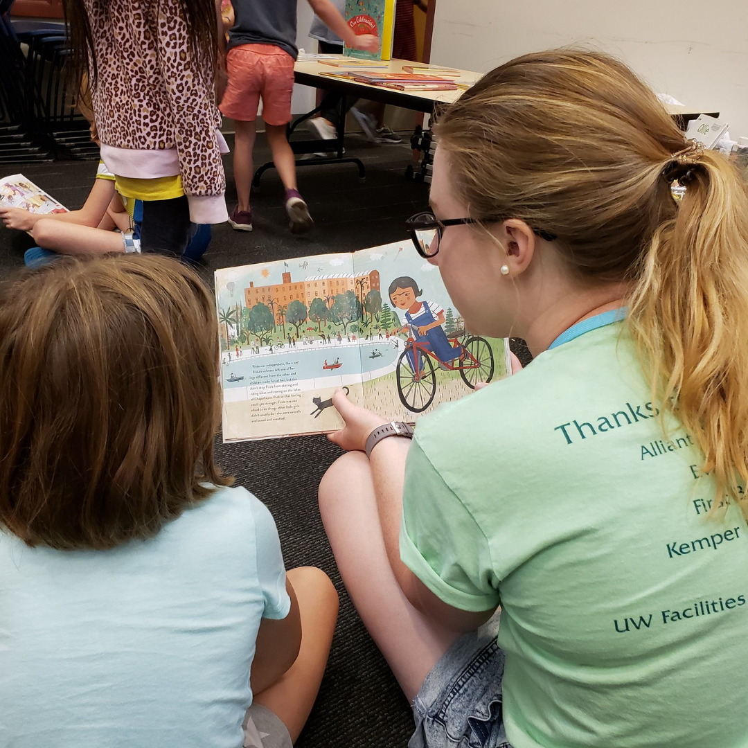 A child reads with an adult during Arts in the Alley