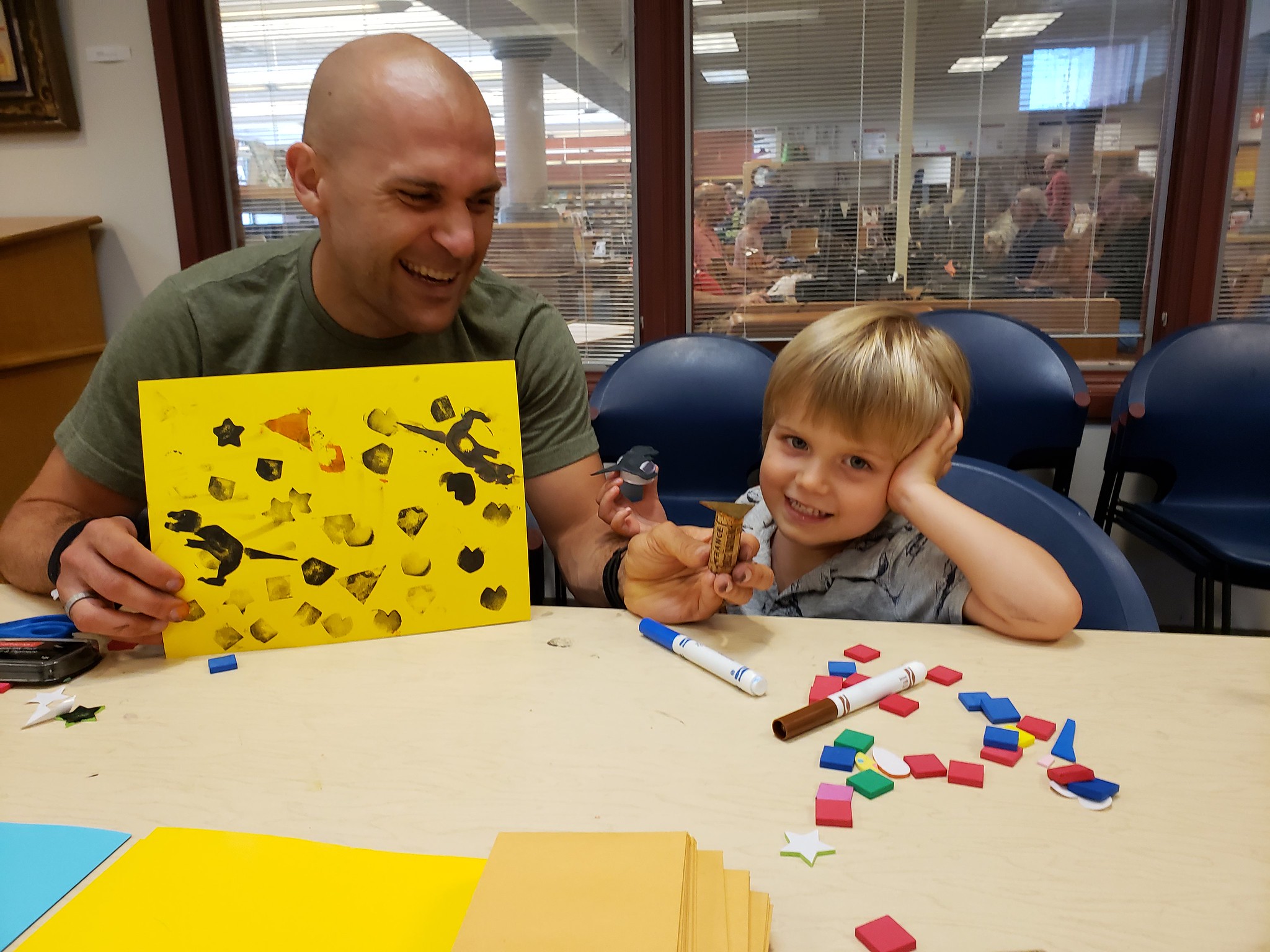 Parent and child show off their stamp-making creation