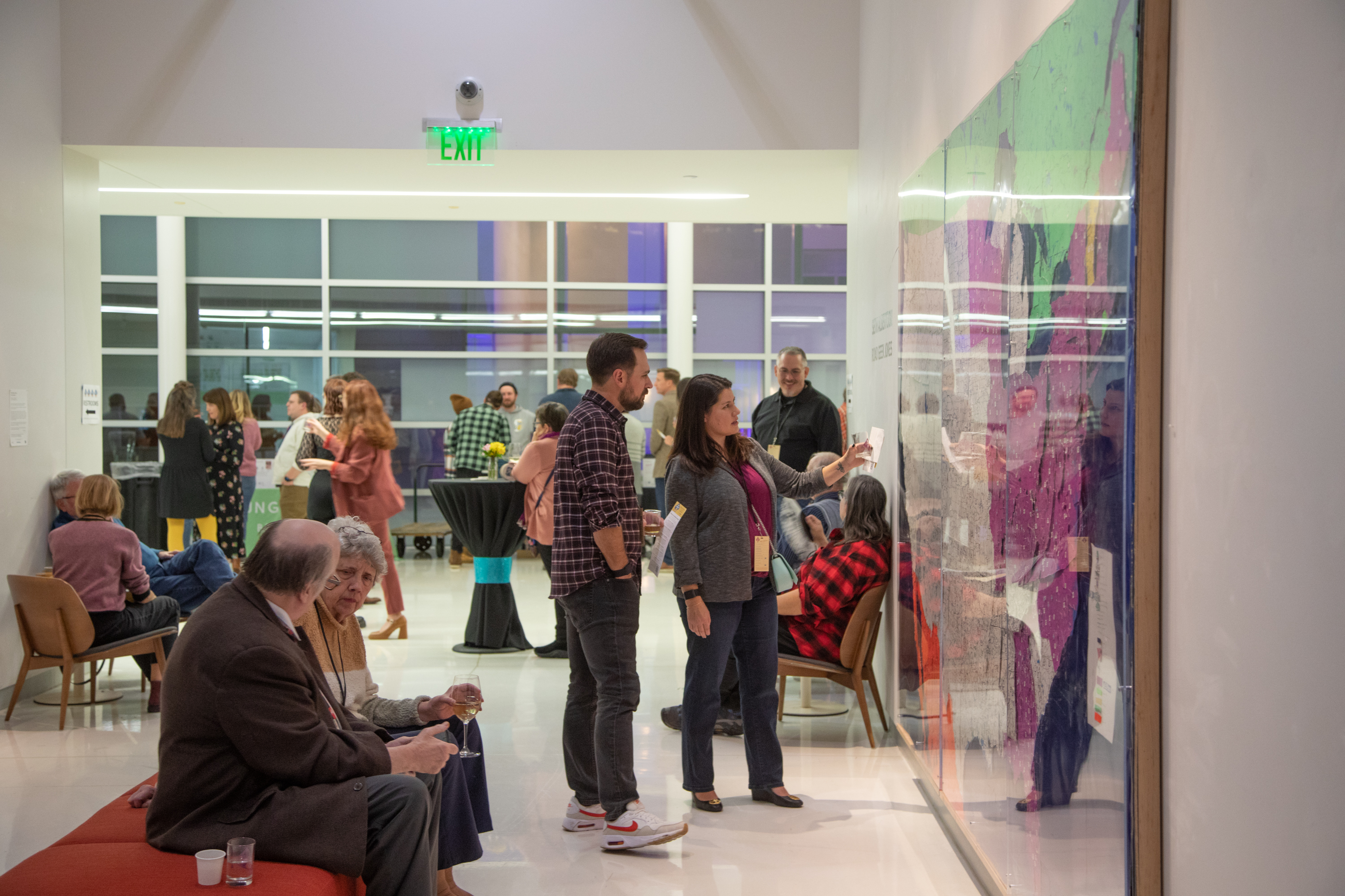 Group of people sitting in Art Gallery looking at large map on wall