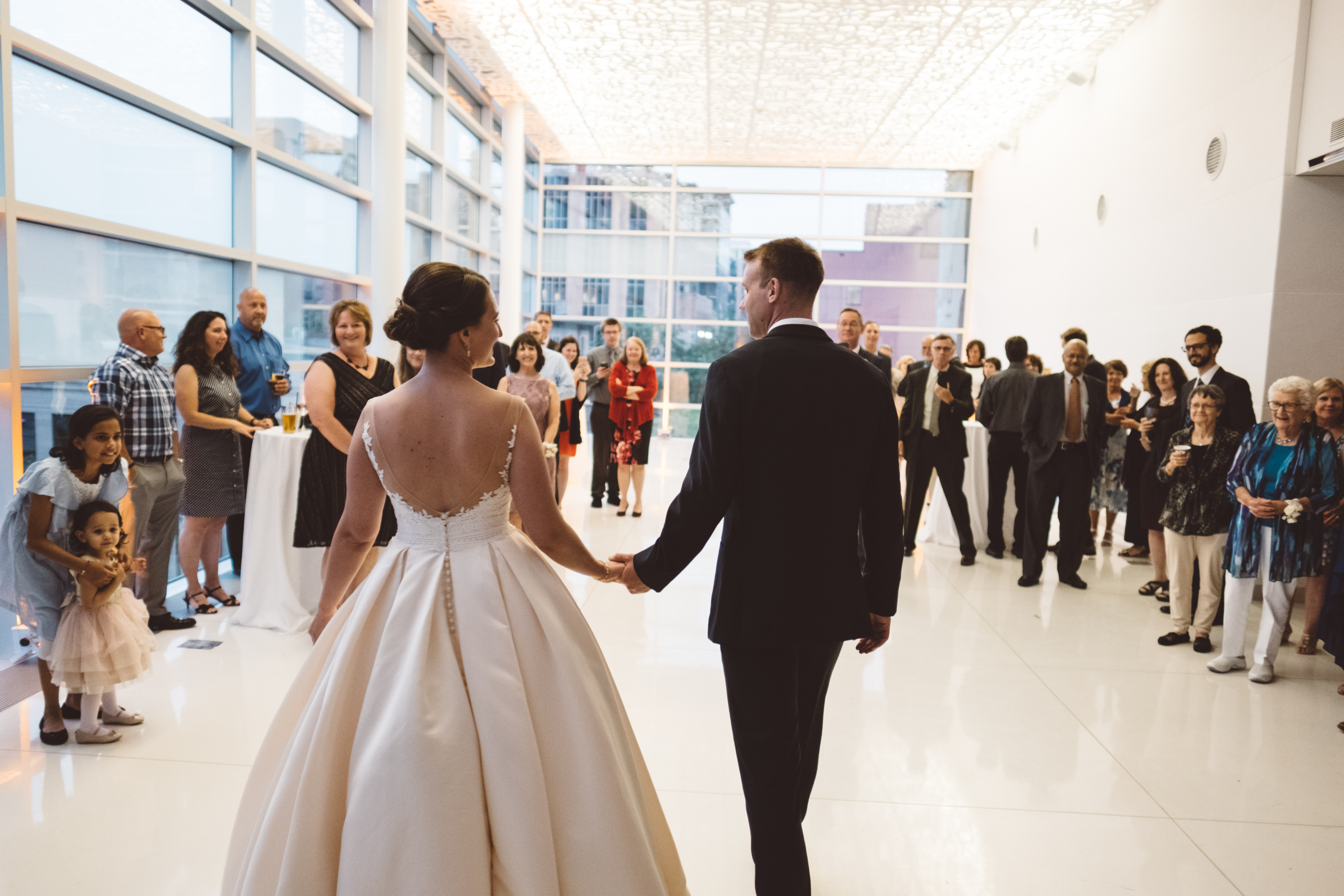 bride and groom entering dance floor in front of wedding guests