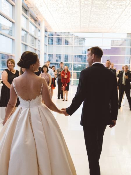 bride and groom entering dance floor in front of wedding guests