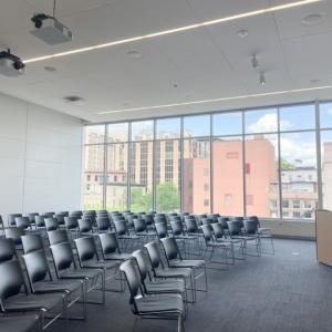 rows of chairs in front of large window facing a person standing at a podium