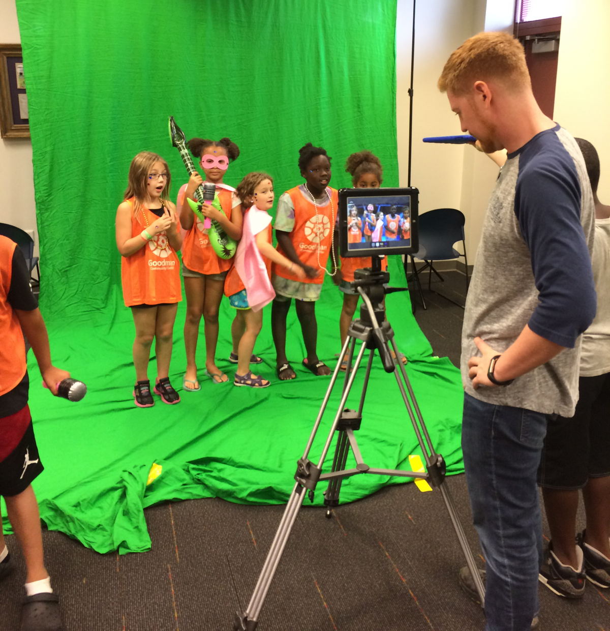 group of girls recording a music video at the library in front of a green screen